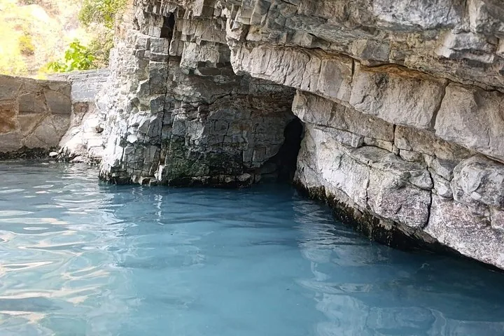 Becken mit blauem Wasser, umgeben von Felswänden in einer Schlucht.